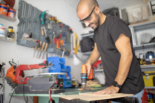 Fotografie Man at work, Working man, repairs a piece of wood and constructs  objects