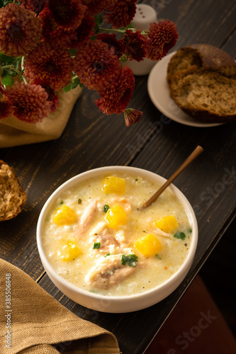 Obraz na płótnie Chicken, rice and pumpkin soup in a plate with a spoon, delicious lunch or break