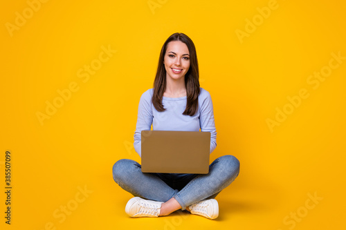 Full length photo of positive confident smart girl sit floor legs crossed work remote laptop texting typing report wear purple outfit isolated over bright shine color background