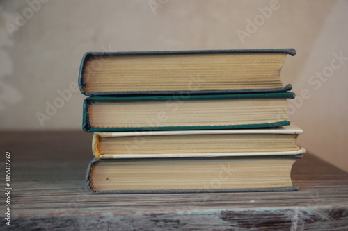 four books on old table egde. Knowledge conceptfocus selected photo