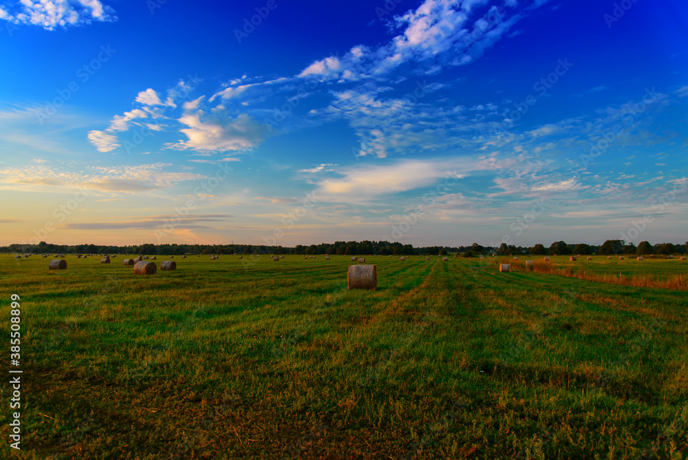 End of day over field with hay bale