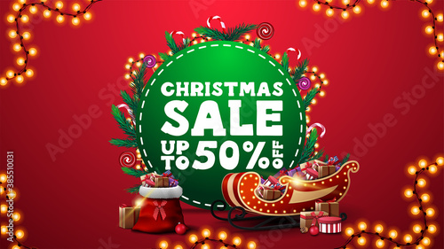 Christmas sale, up to 50% off, vertical red discount banner with green circle with offer, decorated with Christmas tree branches, candys and garlands and Santa Claus sleigh and bag with presents