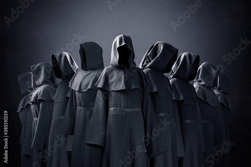 Photo Group of nine scary figures in hooded cloaks in the dark