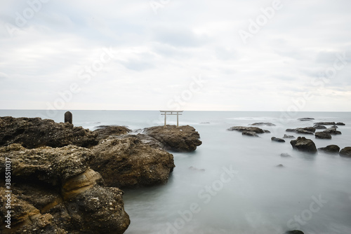 rocks and sea with torii gate