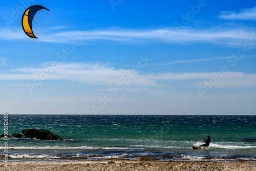 A young man kitesurfing in Tarifa , province of Cadiz , Spain
