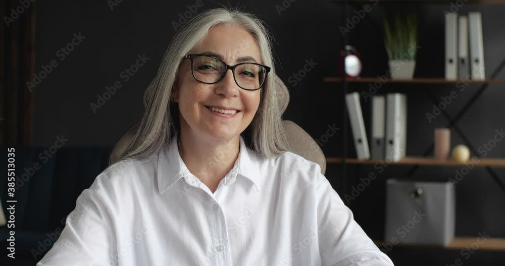Portrait of Happy mature middle-aged Businesswoman is smiling at the Camera. Attractive old senior Female is working on Freelance from Home Office, Progressive People. Easy Technology. Portrait of Happy mature middle-aged Businesswoman is smiling at the Camera. Attractive old senior Female is working on Freelance from Home Office, Progressive People. Easy Technology.