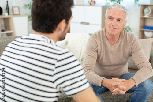 old father talking with son having pleasant conversation