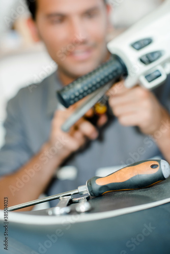 Mechanic working on scooter, blurred background