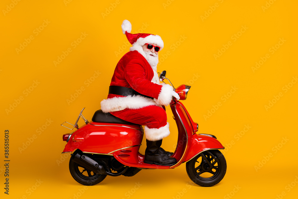 Profile side view of his he nice funny thick white-haired Santa riding motor bike fast speed hurry up rush sale hat ball fly race rally isolated bright vivid shine vibrant yellow color background Profile side view of his he nice funny thick white-haired Santa riding motor bike fast speed hurry up rush sale hat ball fly race rally isolated bright vivid shine vibrant yellow color background