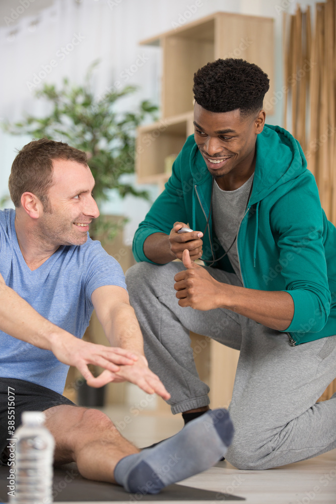 Obraz premium personal trainer working with middle-aged man in his home