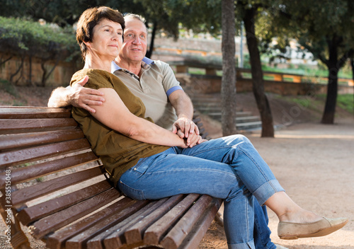 mature man with a woman sitting on bench