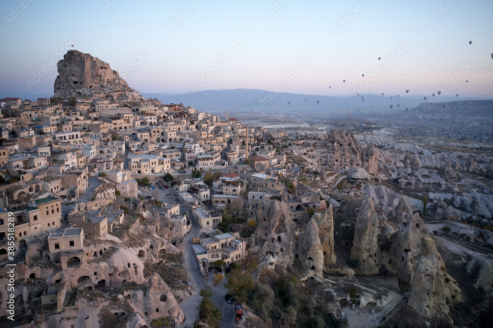 Beautiful view of an ancient city at sunset. Architecture of old town of Ortahisar. Goreme, Cappadocia, Turkey.