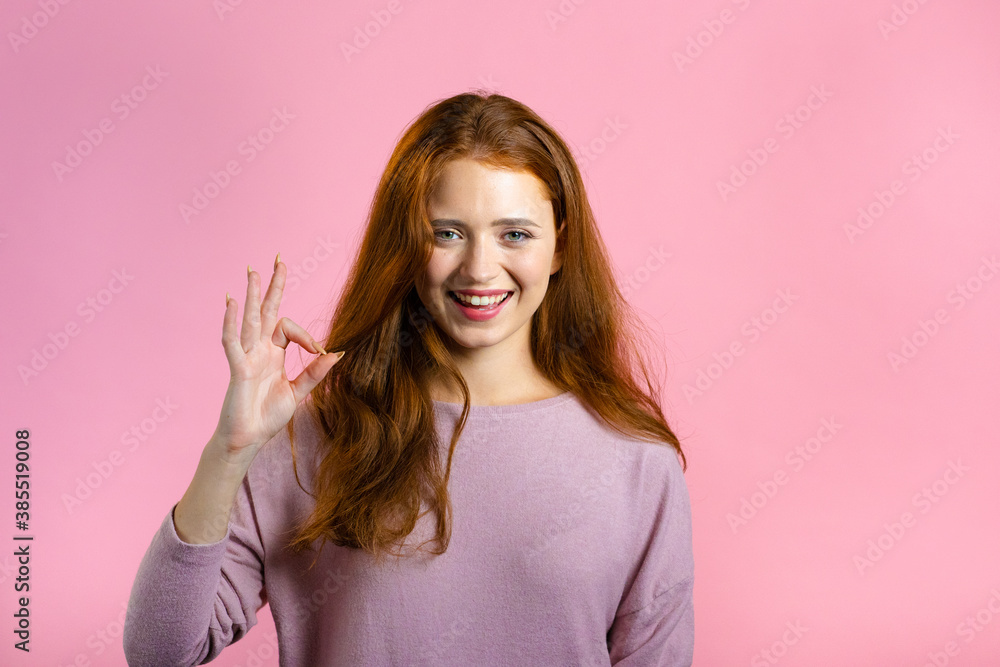 Cute woman showing thumb up sign over pink background. Positive young girl smiles to camera. Winner. Success. Body language. Cute woman showing thumb up sign over pink background. Positive young girl smiles to camera. Winner. Success. Body language.