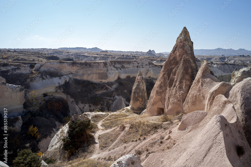 Rock formations in Goreme valley, Turkey. Unusual mountain landscape of Cappadocia on a summer day. Blue sky in the background.