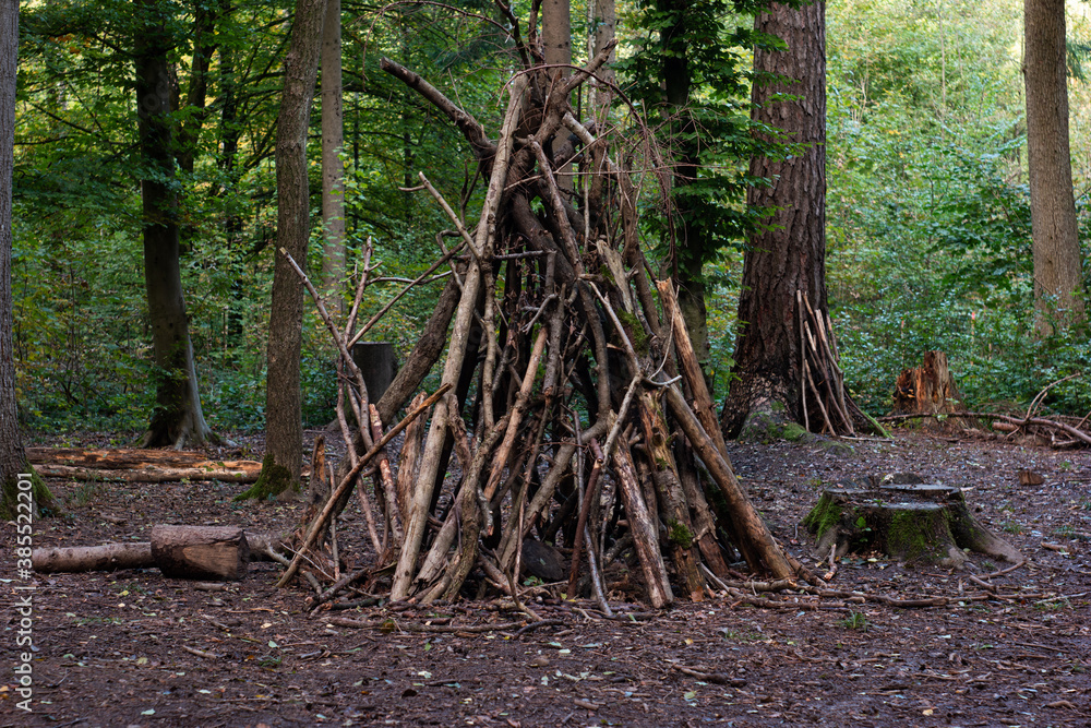 Forest camp site tall wooden tent made of branches autumn day Forest camp site tall wooden tent made of branches autumn day