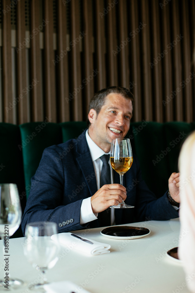 Handsome businessman drinking wine. Businessman enjoying in the restaurant Handsome businessman drinking wine. Businessman enjoying in the restaurant