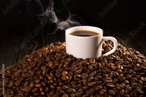 A cup of coffee on the background of coffee beans.