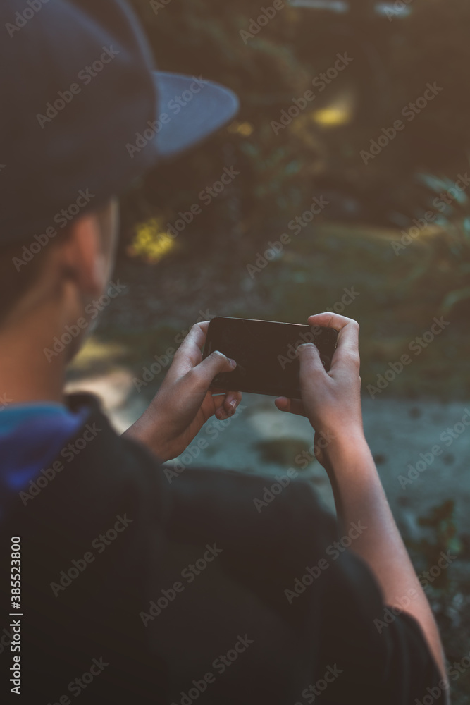 Young guy holding his own phone. Guy controlling his phone.