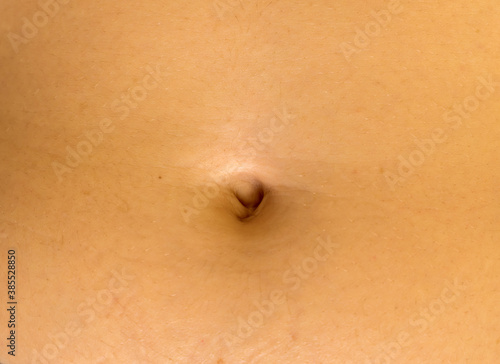 The close-up view of a navel of unrecognizable young caucasian female.