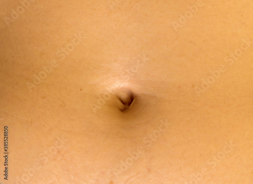 Bild auf Leinwand The close-up view of a navel of unrecognizable young caucasian female