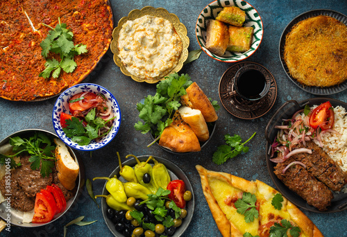 Traditional Turkish food, assorted dishes and mezze appetizers on rustic background from above. Pide, Lahmacun, meat kebab, Turkish meatballs, sweet baklava and Künefe. Middle East cuisine, top view
