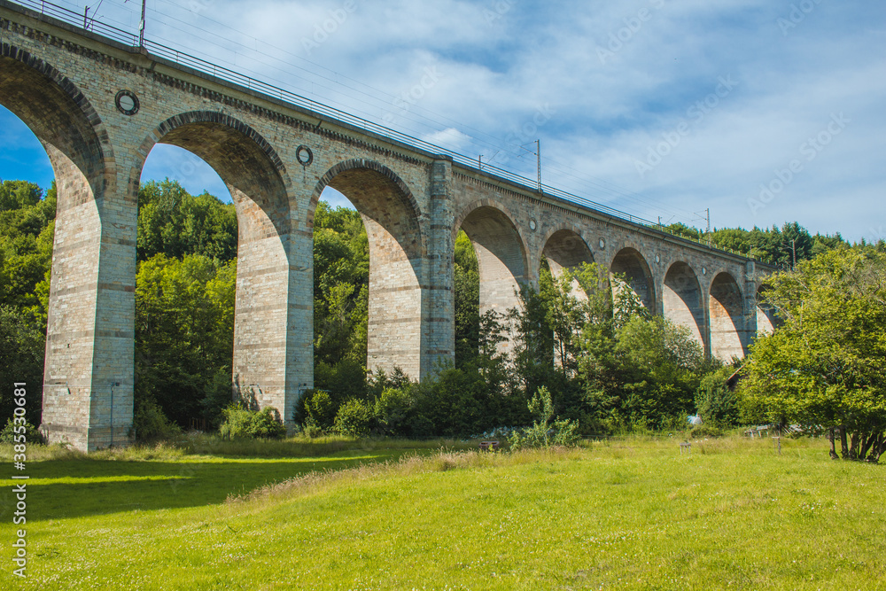 Train viaduct in Altenbeken,  North Rhine Westphalia, Germany. Old stone railway surrounded by green park