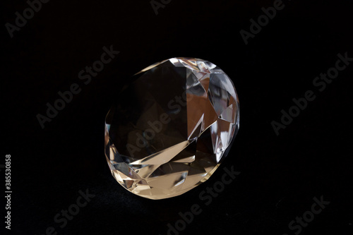 Diamond shaped transparent decorative crystal with black background.