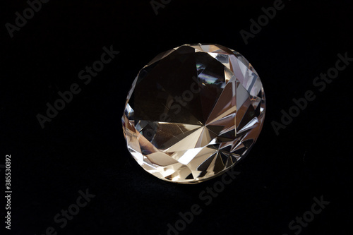 Diamond shaped transparent decorative crystal with black background.