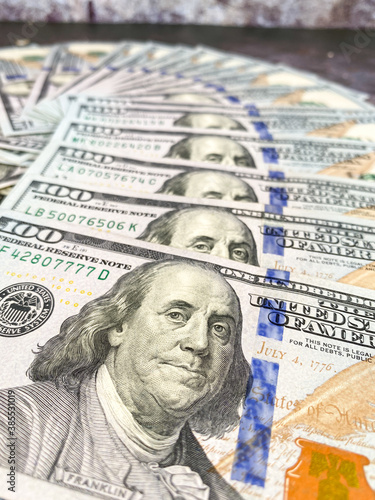 100 Dollars bill and portrait Benjamin Franklin on USA money banknote. Close up of one hundred dollar bills on table.