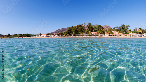 Clear turquoise water of Aegean sea and Caraincir beach. Beautiful Mediterranean seascape of ripple water with sunbeams reflections. Province of Mugla, Datca peninsula, Turkey 