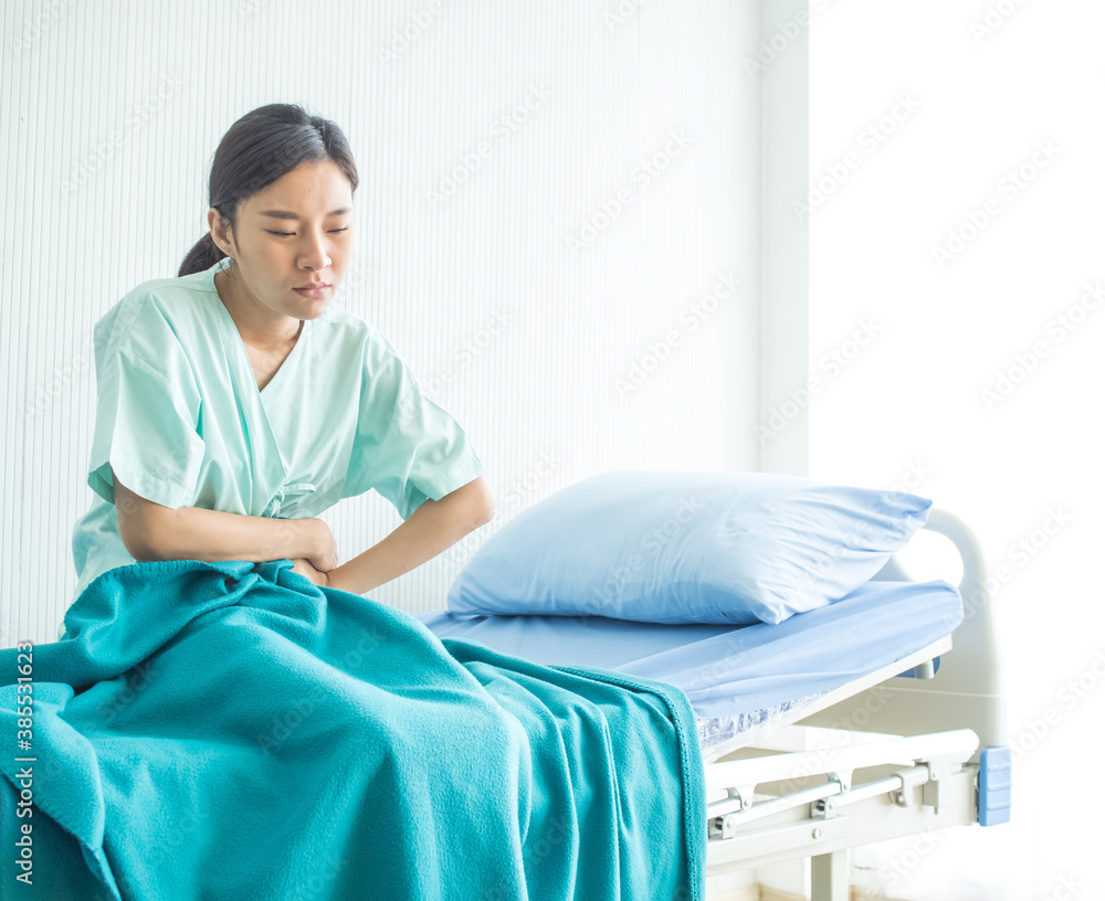 Hospital clinic lab or laboratory copy space female patient green uniform is siting on the bed for treatment health care flu ill sick sneeze stomache and covid-19 corona virus disease Hospital clinic lab or laboratory copy space female patient green uniform is siting on the bed for treatment health care flu ill sick sneeze stomache and covid-19 corona virus disease