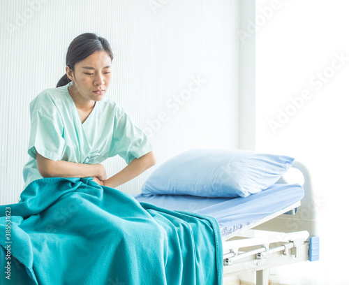 Hospital clinic lab or laboratory copy space female patient green uniform is siting on the bed for treatment health care flu ill sick sneeze stomache and covid-19 corona virus disease 