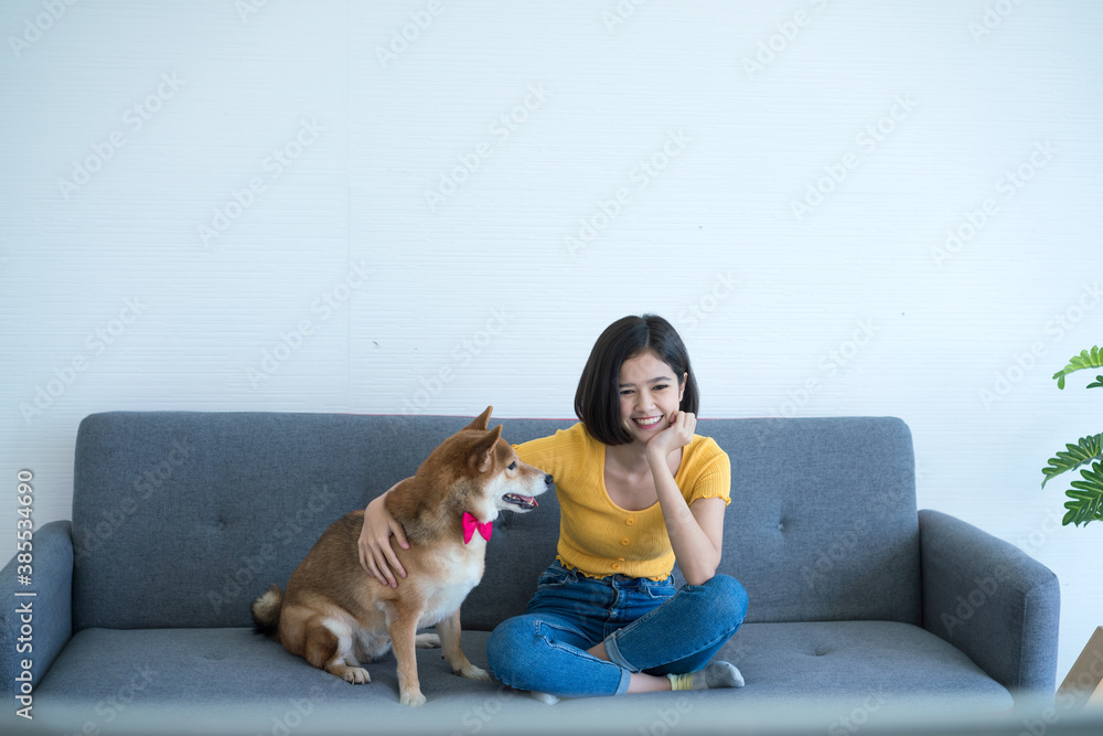 A girl sitting watching television with a Shiba Inu dog.