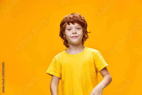 Boy red hair yellow t-shirt isolated background cropped view
