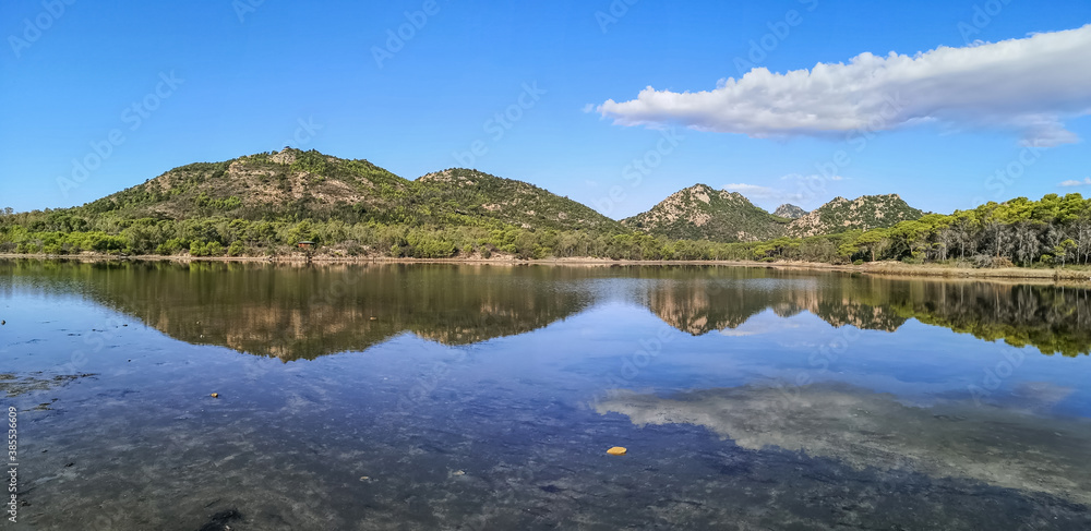 ultra wide panorama of a mountains reflected in a lake in Sardinia