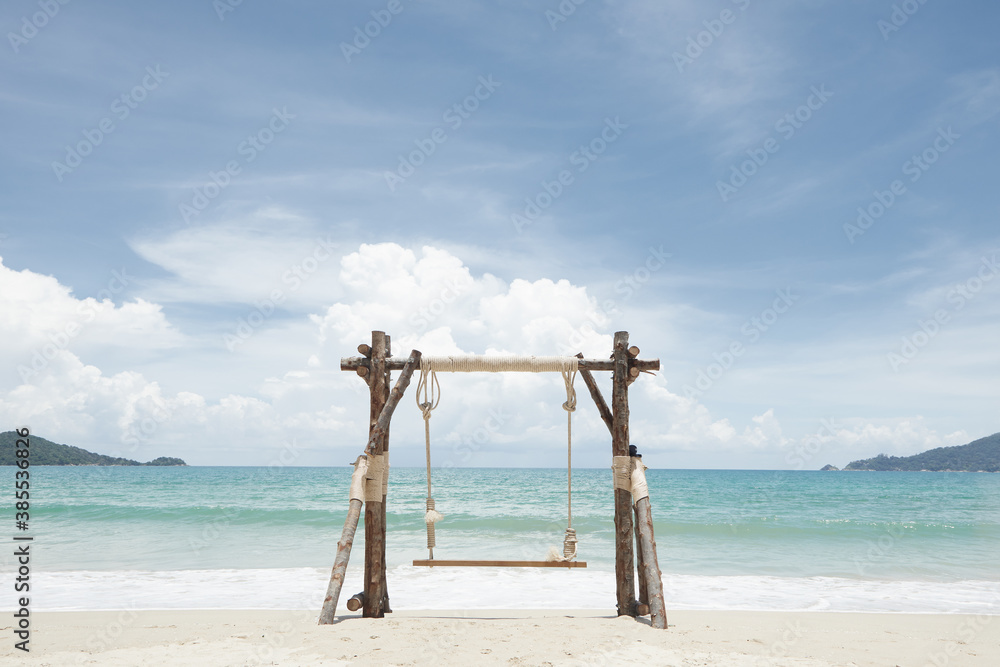 View of nice wooden swing on summer tropic beach
