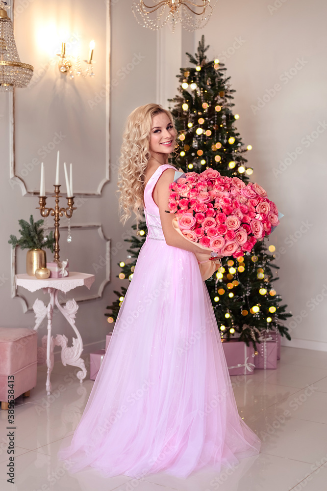Beautiful girl woman near christmas tree smiling dancing in beautiful dress in decorated house, happy new year