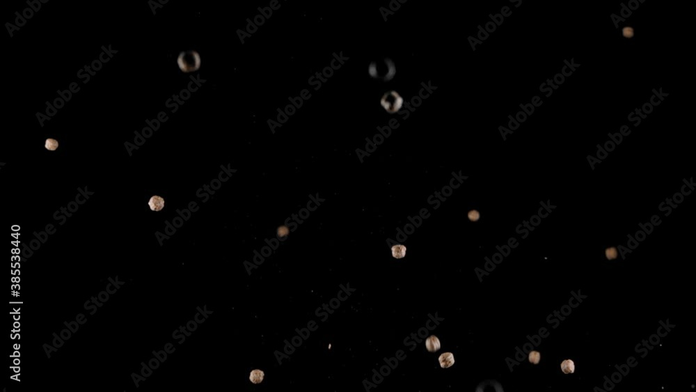 few Chocolate Cereals corn balls flying and falling slow motion isolated on black backdrop. Less chocolate less calories. Healthy nutrition concept. Fighting chocolate addiction few Chocolate Cereals corn balls flying and falling slow motion isolated on black backdrop. Less chocolate less calories. Healthy nutrition concept. Fighting chocolate addiction