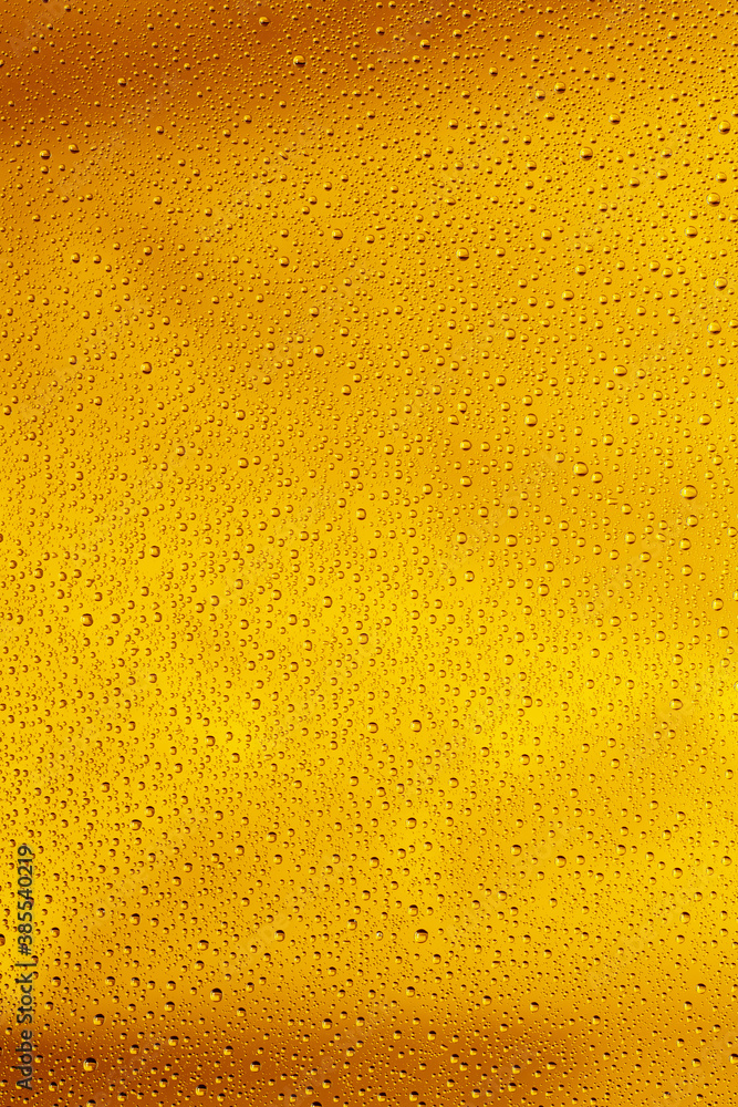 Close up view of cold drops on the glass of beer background. Texture of cooling alcohol drink with macro bubbles on the glass wall. Fizzing or floating up to top of surface. Golden colored. Close up view of cold drops on the glass of beer background. Texture of cooling alcohol drink with macro bubbles on the glass wall. Fizzing or floating up to top of surface. Golden colored.