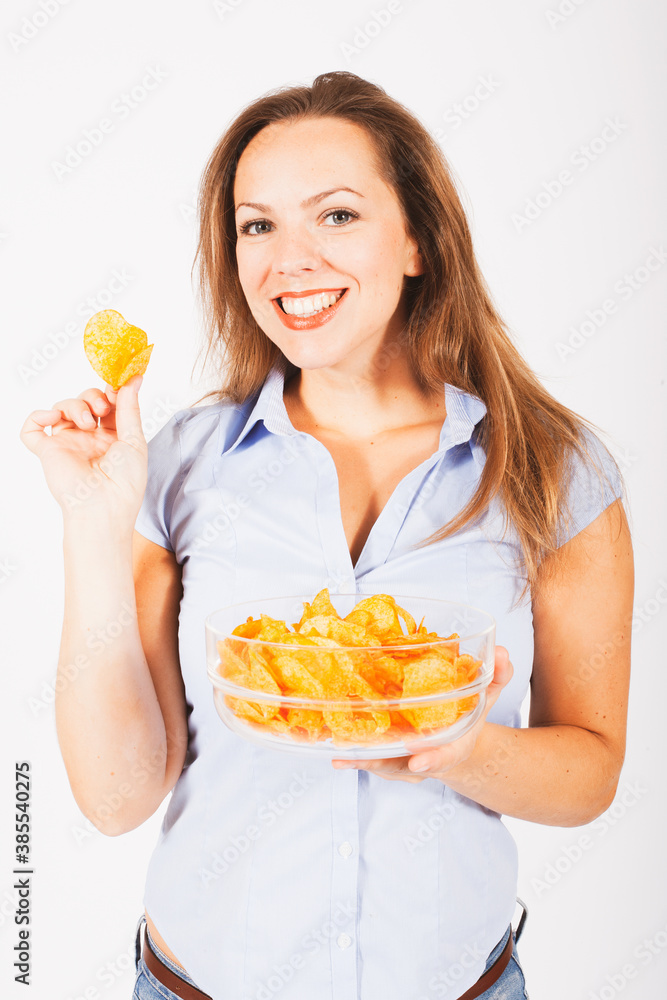 blond woman standing and eating potato chips from a bowl blond woman standing and eating potato chips from a bowl