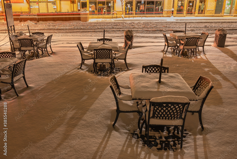 Patio dining tables with winter snow in Canmore, Alberta, Canada