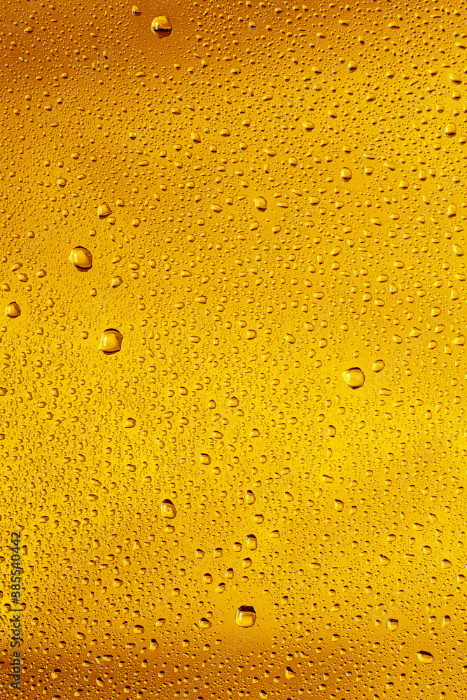 Close up view of cold drops on the glass of beer background. Texture of cooling alcohol drink with macro bubbles on the glass wall. Fizzing or floating up to top of surface. Golden colored. Close up view of cold drops on the glass of beer background. Texture of cooling alcohol drink with macro bubbles on the glass wall. Fizzing or floating up to top of surface. Golden colored.