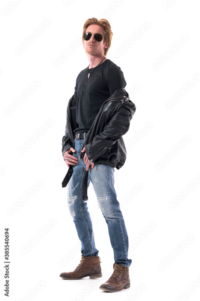 Fashionable macho biker man fashion model in taking off black leather jacket posing. Full body isolated on white background. Fashionable macho biker man fashion model in taking off black leather jacket posing. Full body isolated on white background.