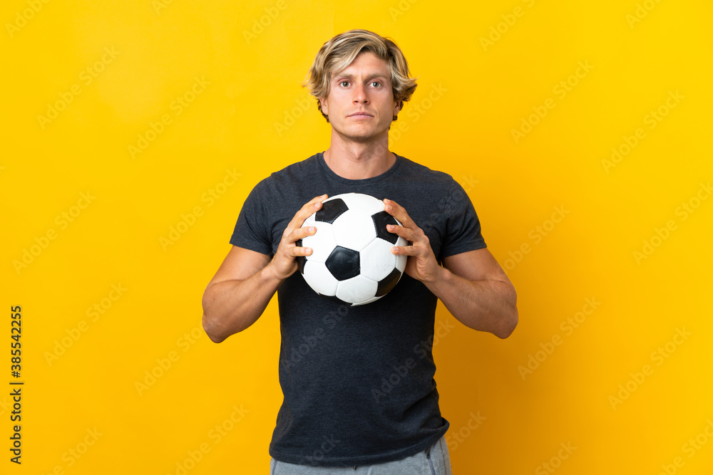 English man over isolated yellow background with soccer ball English man over isolated yellow background with soccer ball