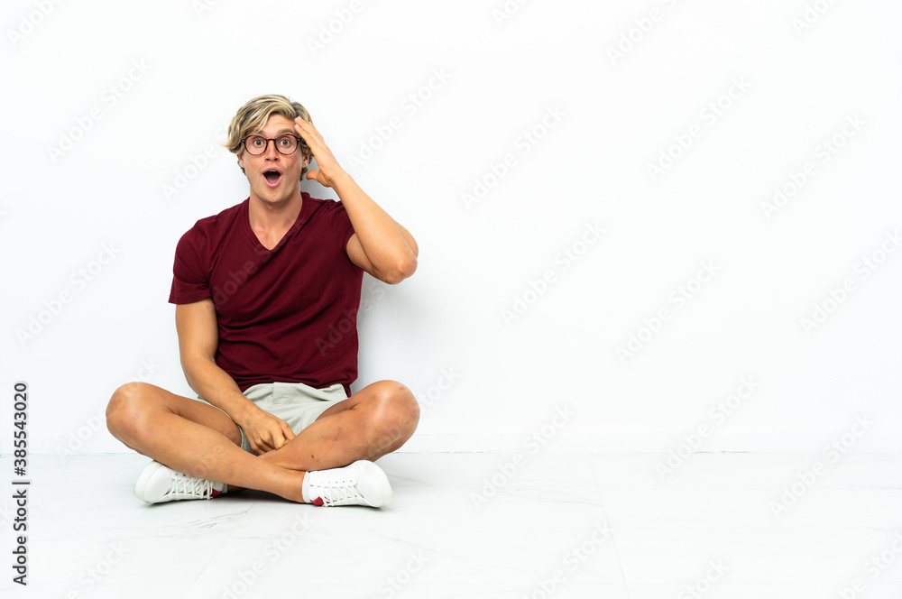 Young English man sitting on the floor has realized something and intending the solution
