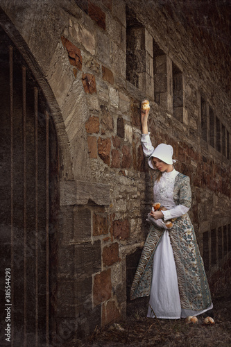 Young village woman trying to distribute bread buns to prisoners in an old dungeon © ArtMood Visualz