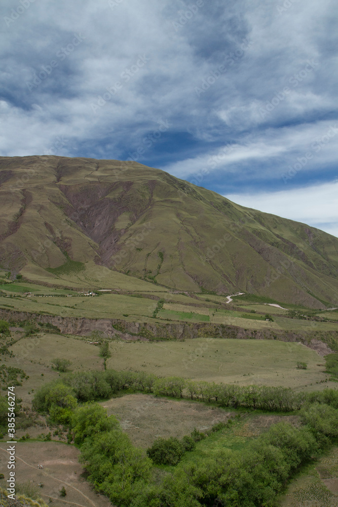 Fototapeta premium The green valley and hills under a blue sky. View of the popular landmark Bishop's slope in Salta, Argentina.