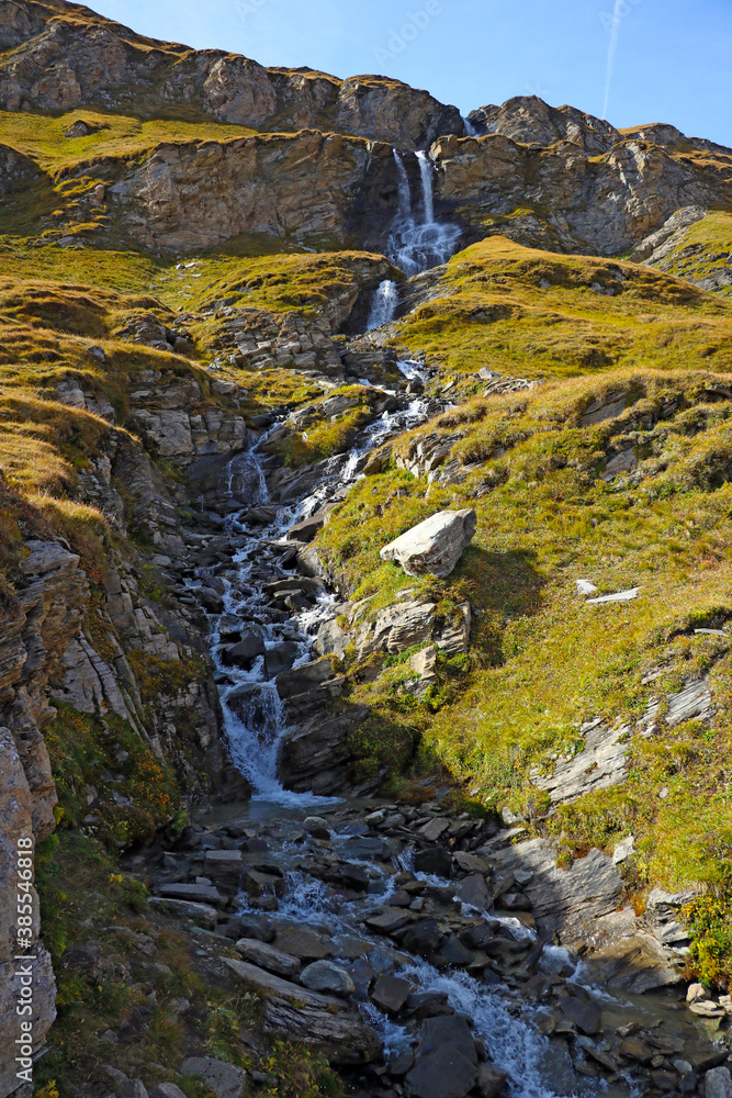 Obraz premium A small stream flows down the mountainside.