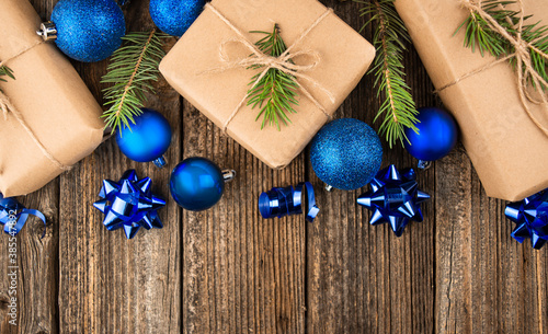 Christmas background from blue toys and gift boxes on a wooden background. Flat lay, top view, copy space.