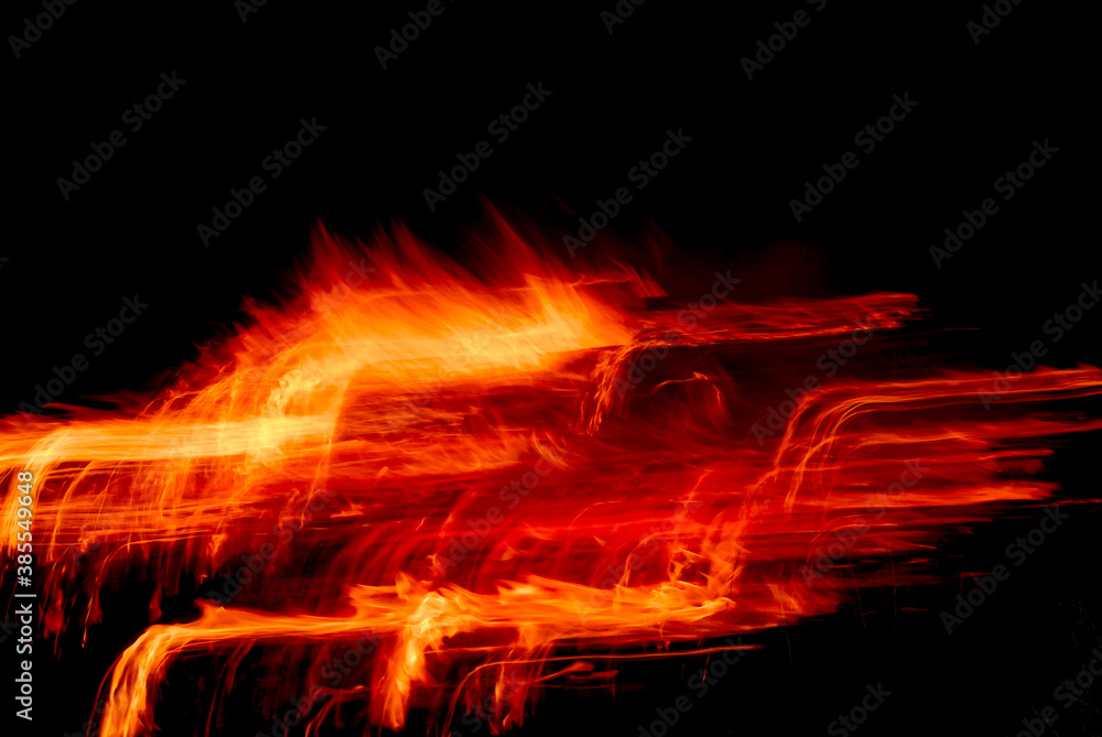 Fototapeta premium Fire sparks create imaginative yellow orange light trail pattern on black, creative effects for backgrounds